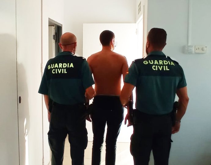 Dos agentes de la Guardia Civil escoltan a un detenido.