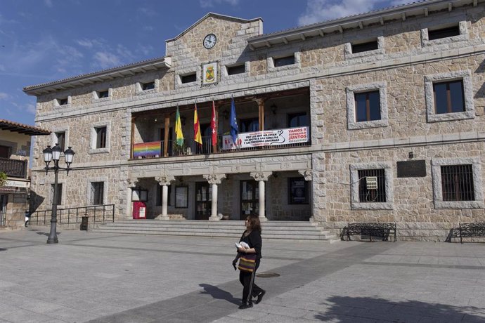 Archivo - Una mujer pasea sin mascarilla, frente al ayuntamiento de Manzanares El Real.