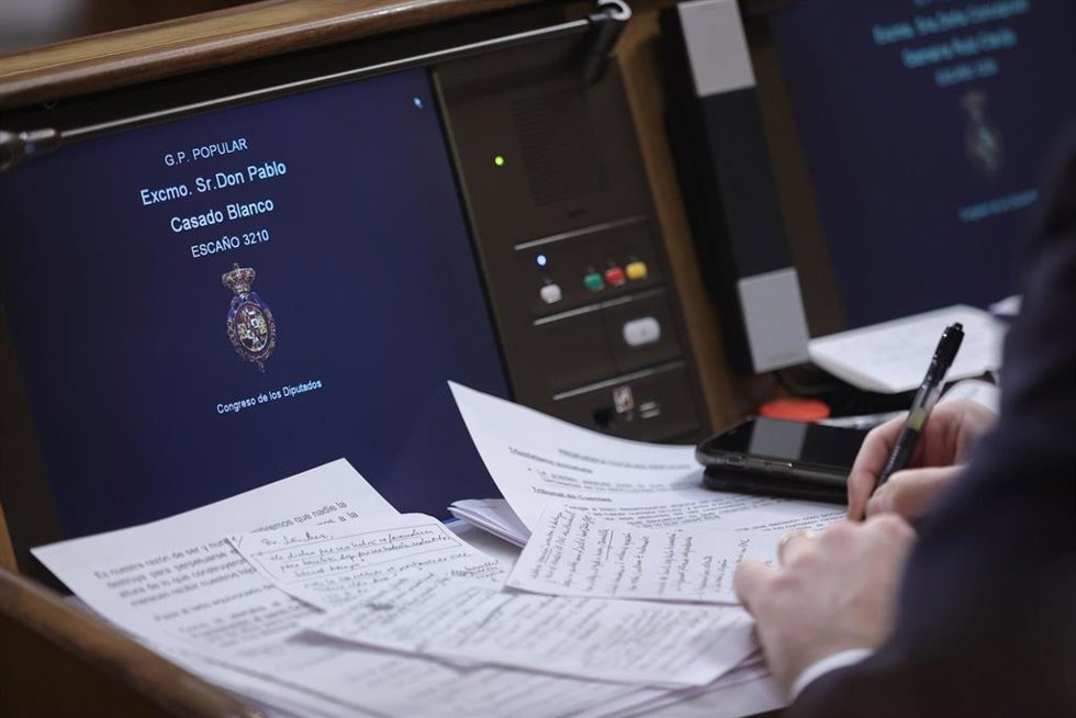 Archivo - El líder del PP, Pablo Casado, escribe en su asiento del hemiciclo durante una sesión de control al Gobierno en el Congreso