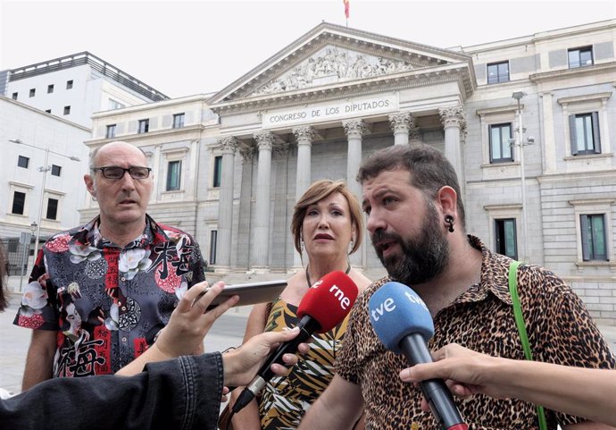 El presidente del Observatorio Contra la Homofobia de Cataluña, Eugeni Rodríguez; la presidenta de la Plataforma Trans, Mar Cambrollé; y el representante del Observatorio Contra la LGTBI+fobia de Vitoria-Gasteiz, Amets Martínez delante del Congreso.