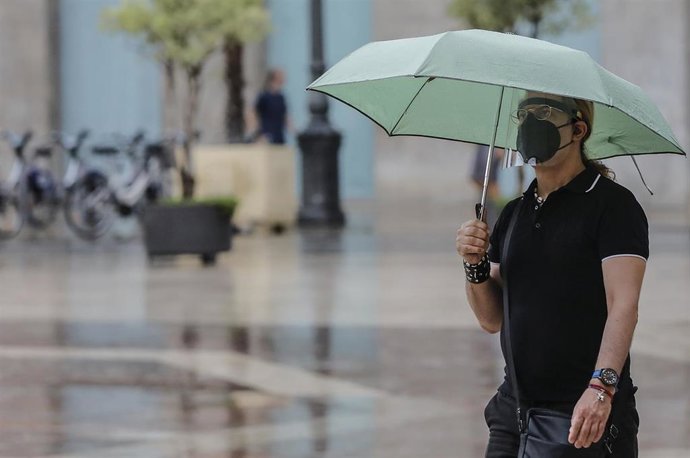 Archivo - Una persona sostiene un paraguas mientras llueve, a 26 de julio de 2021, en Valencia, Comunidad Valenciana, (España).