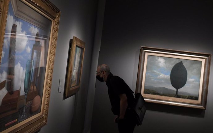Una persona observa una de las obras de la exposición La máquina de Magritte en el Museo Nacional Thyssen-Bornemisza