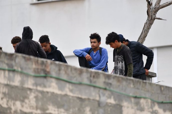 Varios menores migrantes, en el tejado de una nave industrial, a 27 de agosto de 2021, en Ceuta, (España). 