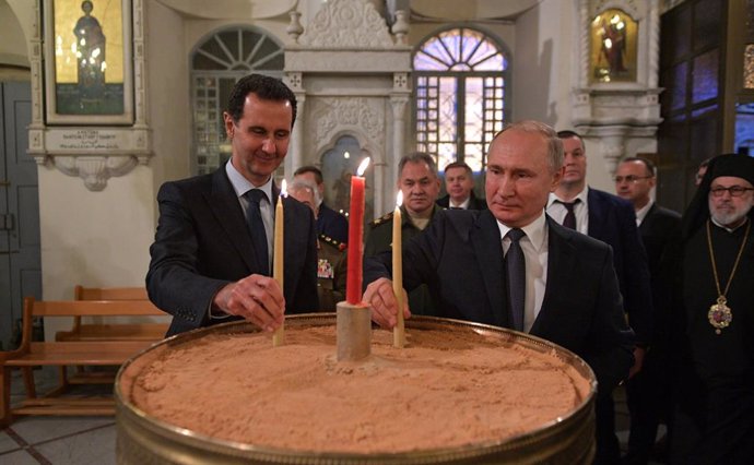 Archivo - HANDOUT - 07 January 2020, Syria, Damascus: Russian President Vladimir Putin (C) and Syrian President Bashar Assad light candles during their visit to the Mariamite Cathedral of Damascus. Photo: -/Kremlin/dpa