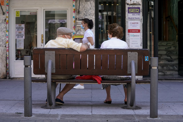 Una pareja de ancianos con mascarilla sentada en un banco, a 27 de julio de 2021, en Madrid, (España).