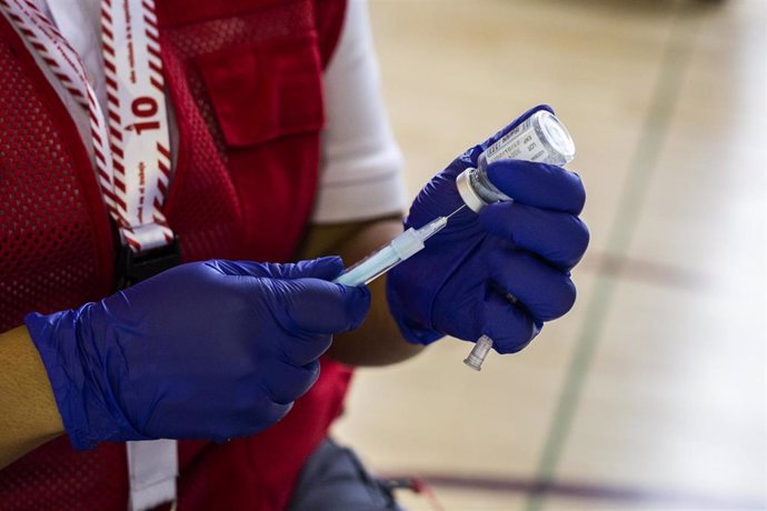 Una voluntaria de Cruz Roja prepara una dosis de la vacuna de Moderna contra el Covid-19 para un estudiante universitario en el campus de Ciudad Universitaria.