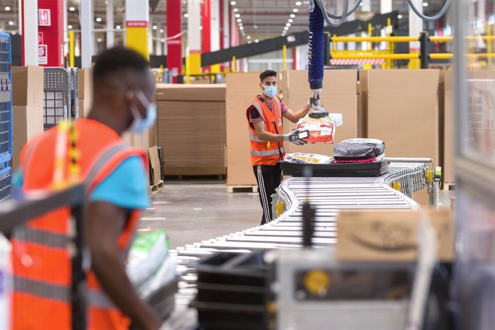 Archivo - Un empleado de Amazon utiliza una máquina de precintado automática