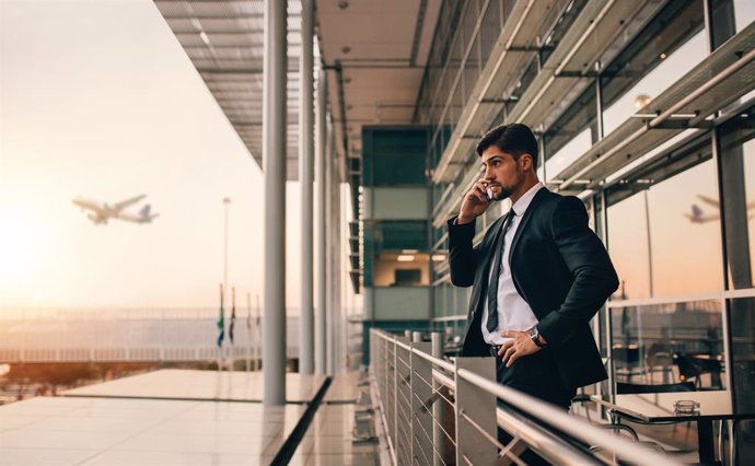 Archivo - Hombre de negocios en un aeropuerto realizando una llamada telefónica.