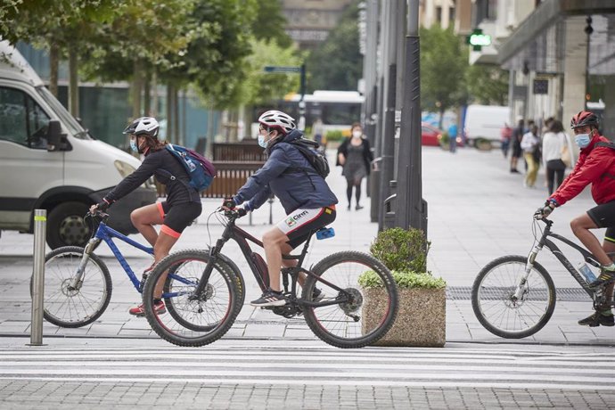 Archivo - Personas en bici y con mascarilla en una céntrica calle de Pamplona