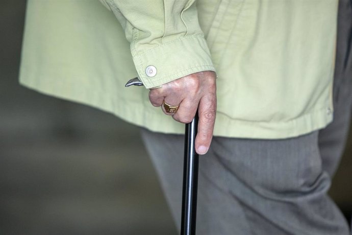 Archivo - Un anciano camina ayudado de un bastón.