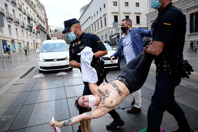 Agentes de policía nacional llevan a una activista de Femen durante una protesta convocada frente al Congreso de los Diputados, a 15 de septiembre de 2021, en Madrid, (España). Al grito de Fuera homofobia del Congreso, las activistas han convocado est