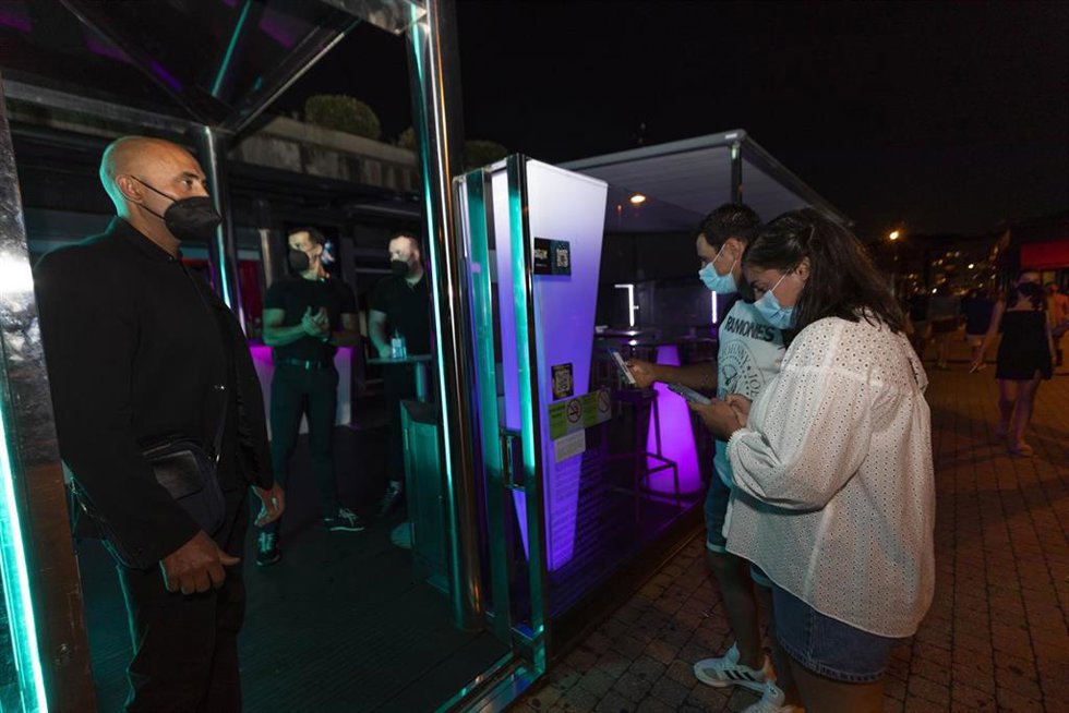 Archivo - Personas esperan para poder acceder a un local de ocio nocturno