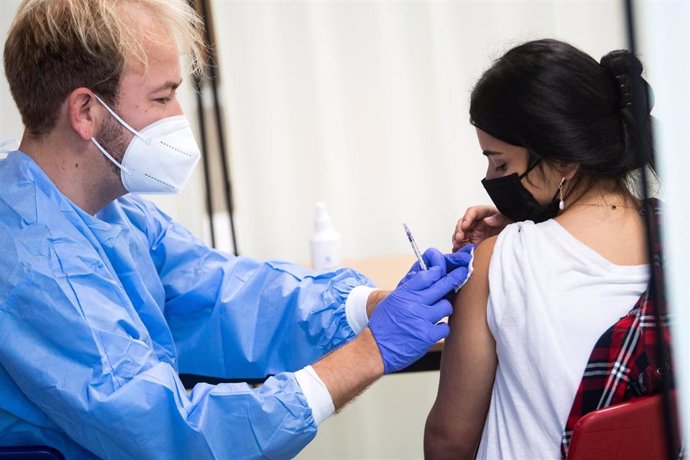 13 September 2021, Berlin: High school student Sakine gets vaccinated with Moderna by Henning Spliedt (L) during a vaccination campaign of Malteser Hilfsdienst at Ruth-Cohn-Schule in Berlin-Charlottenburg to kick off the campaign week "#HierWirdGeimpft"