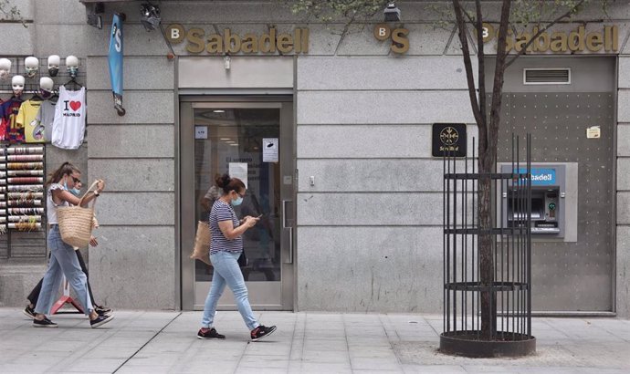 Varias personas pasan por una sucursal de Banco Sabadell, a 2 de septiembre de 2021, en Madrid (España). Banco Sabadell ha propuesto a los sindicatos un plan de ajuste de su plantilla que contempla el despido de 1.900 empleados.