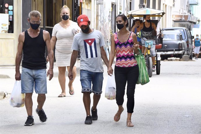 Personas con mascarilla en una calle de La Habana