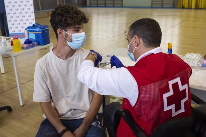 Un voluntario de Cruz Roja administra una dosis de la vacuna contra el Covid-19 a un estudiante universitario en el campus de Ciudad Universitaria, a 14 de septiembre de 2021, en Madrid, (España). 