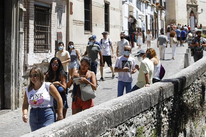 Archivo - Turistas con y sin mascarillas por las calles de Granada, durante el primer día en el que no es obligado el uso de la mascarilla en exteriores desde el inicio de la pandemia, a 26 de junio de 2021