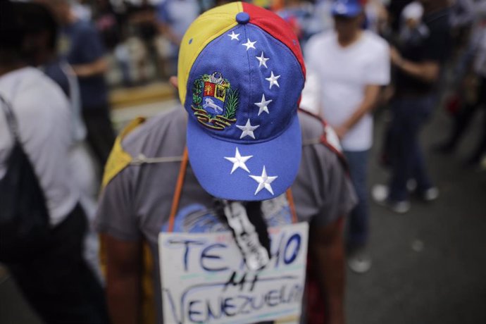 Archivo - Un manifestante con una gorra con los colores de la bandera venezolana sostiene un cartel con "Te quiero, mi Venezuela", durante una protesta contra el Gobierno.