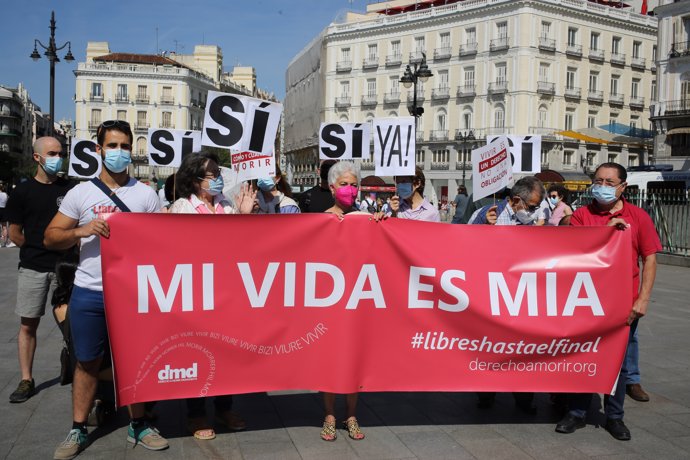 Un grupo de personas se reúne sosteniendo pancartas y carteles durante la concentración de la asociación Derecho a Morir Dignamente (DMD) en la Puerta del Sol, a 25 de junio de 2021