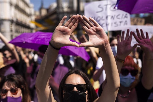 Archivo - Una mujer hace un gesto feminista, durante una manifestación.
