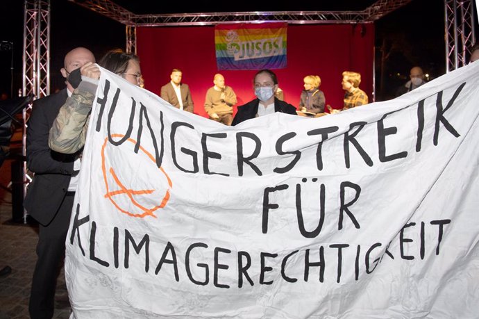 17 September 2021, Brandenburg, Potsdam: Climate activists hold a banner reading "Hunger strike for climate justice" at an election campaign event of Olaf Scholz, German Minister of Finance and Candidate for Chancellor of the Social Democratic Party (SP