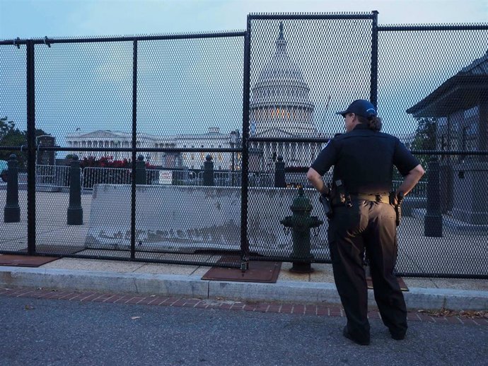 Una agente de la Policía del Capitolio, en Washington DC, supervisa las vallas de seguridad colocadas en preparación de las protestas de este sábado