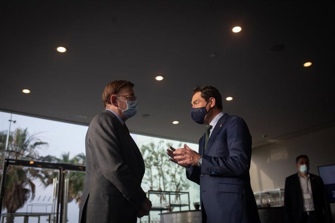 Archivo - El presidente de la Junta de Andalucía, Juan Manuel Moreno Bonilla (d) habla con el presidente de la Generalitat, Ximo Puig, en una imagen de archivo