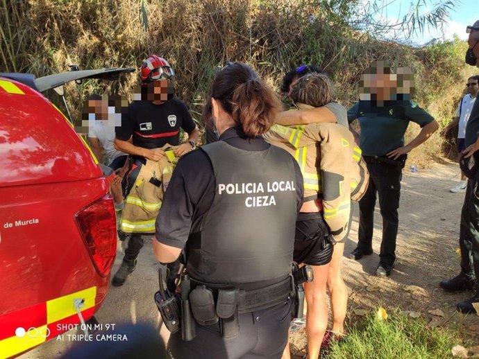 La mujer rescatada se abraza a una amiga una vez puesta a salvo