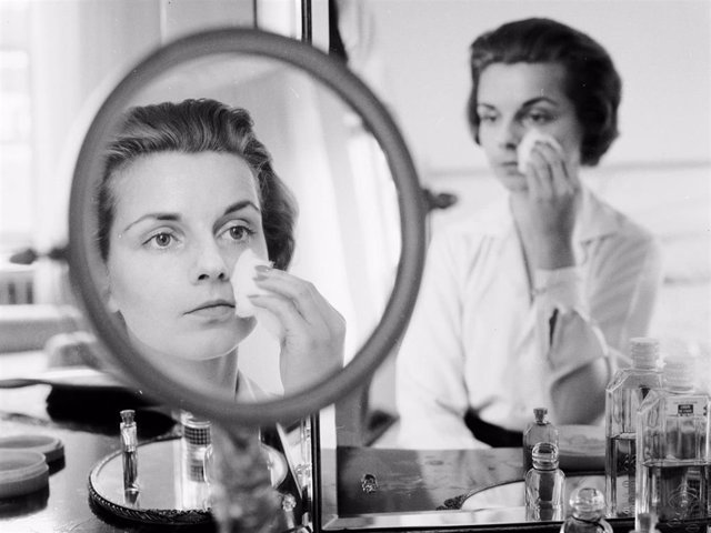 Archivo - A woman rubbing her face with cotton wool to remove make up or apply moisturiser.  (Photo by Jacobsen /Three Lions/Getty Images)