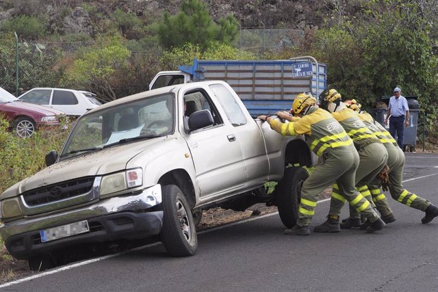 Bomberos ayudan a reincorporar un vehículo a la carretera tras la erupción del volcán de Cumbre Vieja