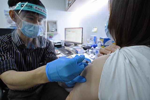 Archivo - Un doctor inocula la vacuna china Sinovac contra el coronavirus en un centro médico de Singapur.