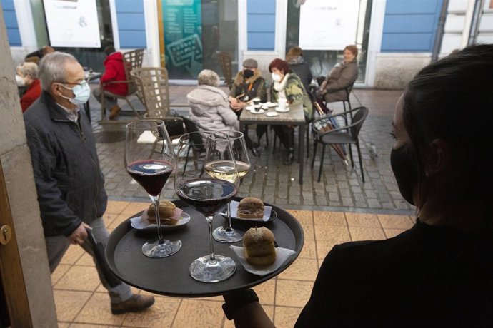 Archivo - Una camarera se dispone a servir en una terraza de un restaurante
