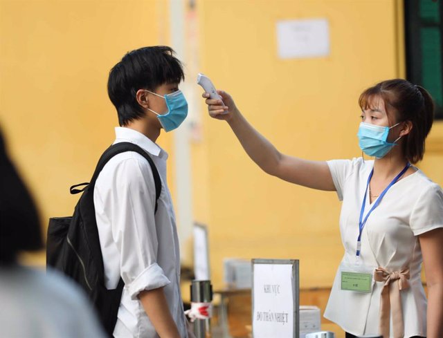 Un joven se somete a un control de temperatura en un centro escolar de Hanói.