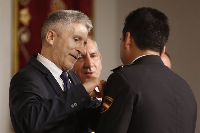 Archivo - El ministro del Interior en funciones, Fernando Grande-Marlaska, entrega medalla al mérito a un policía en 2019.