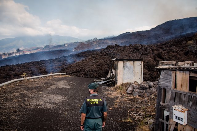 Un guardia civil observa el humo generado por el paso de la lava en La Palma