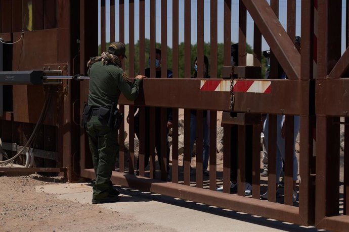 Archivo - Migrantes solicitantes de asilo se entregan a la Patrulla Fronteriza de Estados Unidos en el muro fronterizo con México en Yuma.