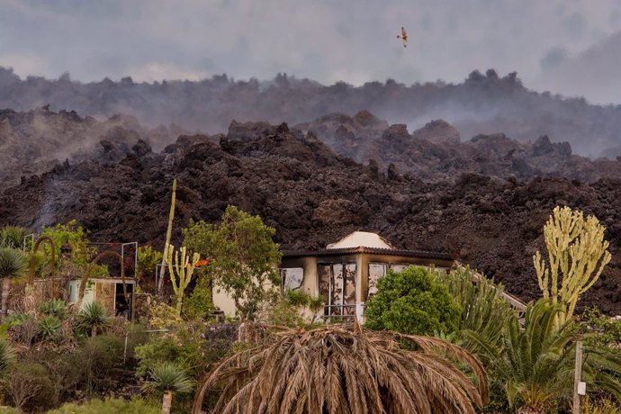 20 September 2021, Spain, La Palma: A house lies under lava and embers after the eruption of the volcano. For the first time in 50 years, a volcano has erupted again on the Spanish Canary Island of La Palma. Photo: Arturo Jiménez/dpa