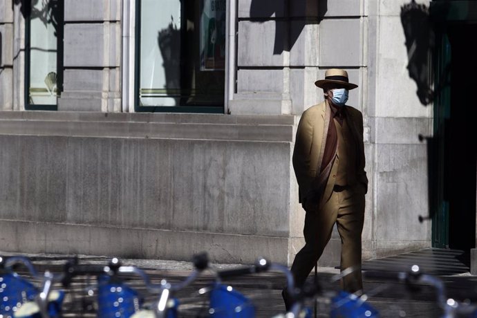 Archivo - Un hombre camina por una calle en Málaga, donde va protegido por una mascarilla por el virus COVID-19. Málaga a 14 de mayo del 2020