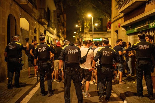 Archivo - Agentes de la Guardia Urbana de Barcelona se dirigen a la multitud para controlar aglomeraciones en las fiestas del barrio de Gràcia, a 19 de agosto de 2021, en Barcelona, Catalunya (España).