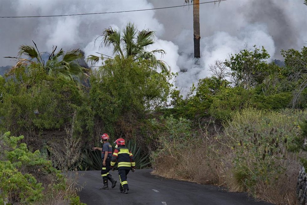 Dos bomberos trabajan en una de las zonas afectadas por la erupción del volcán, a 22 de septiembre