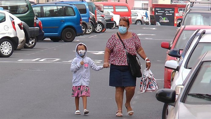 Archivo - Una mujer y una niña caminan con mascarilla.