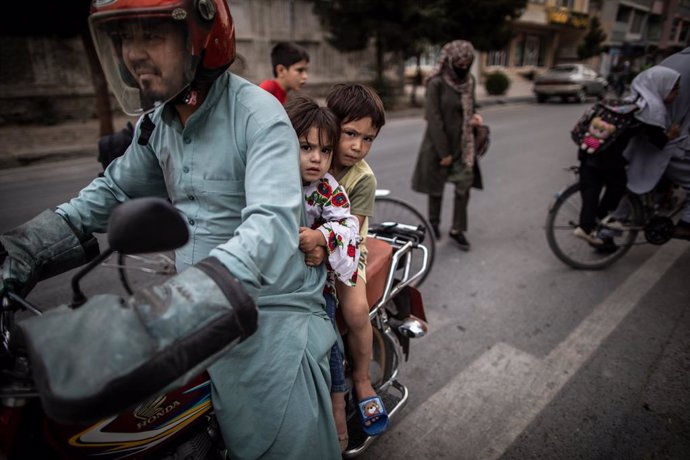 22 September 2021, Afghanistan, Kabul: An Afghan man rides a bike with his children. Photo: Oliver Weiken/dpa