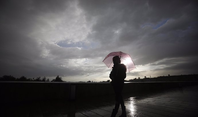 Arxiu - Una dona duu un paraigua per protegir-se de la pluja