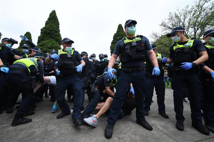 Archivo - Policías con mascarilla y guantes actuando contra manifestantes en una protesta contra el confinamiento en Melbourne, en Australia