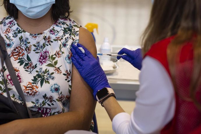 Una voluntaria de Cruz Roja administra una dosis de la vacuna contra el Covid-19 a una estudiante.