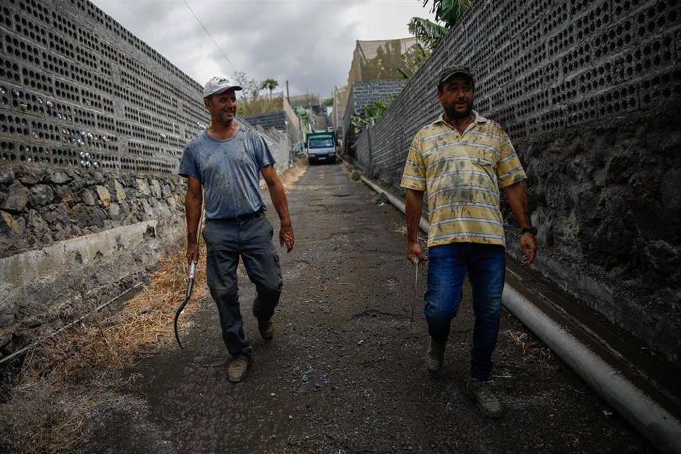 Dos agricultores llenos de ceniza