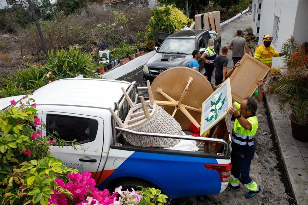 Varias personas de mantenimiento del Ayuntamiento y bomberos colaboran en recoger las pertenencias de los vecinos del núcleo urbano de Todoque durante el desalojo de sus viviendas ante la aproximación de la lava del volcán