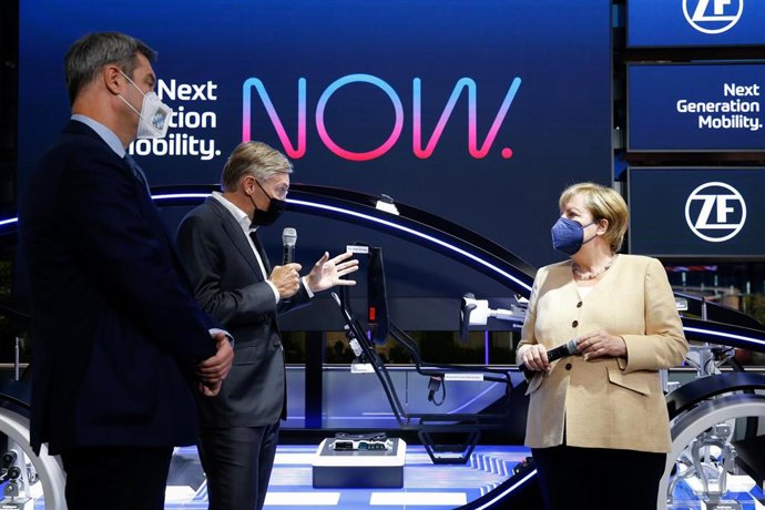 07 September 2021, Bavaria, Munich: Markus Soeder (L), Minister President of Bavaria and German Chancellor Angela Merkel (C) listen to Wolf-Henning Scheider (2nd L), CEO of ZF Friedrichshafen as they stand at the company's booth during the opening of th