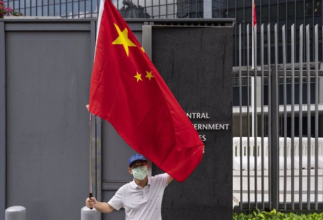 Archivo - 31 March 2021, China, Hong Kong: A pro-Hong Kong Government supporter holds the China flag as he takes part in a gathering outside the Hong Kong government headquarters building to show their support to the government's policy of reforming the e
