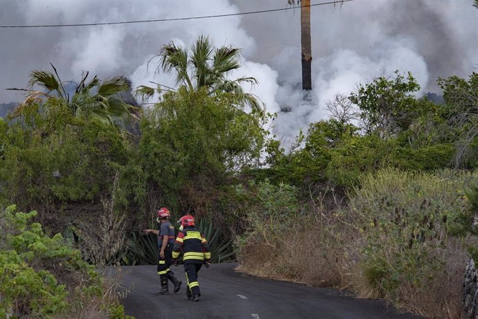 Dos bomberos trabajan en una de las zonas afectadas por la erupción del volcán, a 22 de septiembre de 2021, en La Palma, Santa Cruz de Tenerife, Islas Canarias, (España). La erupción volcánica iniciada el domingo a las 15 horas en la zona de Cabeza de V